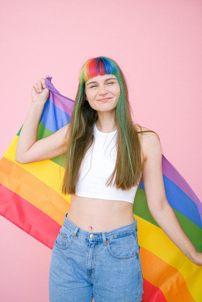 Person smiling and holding pride flag