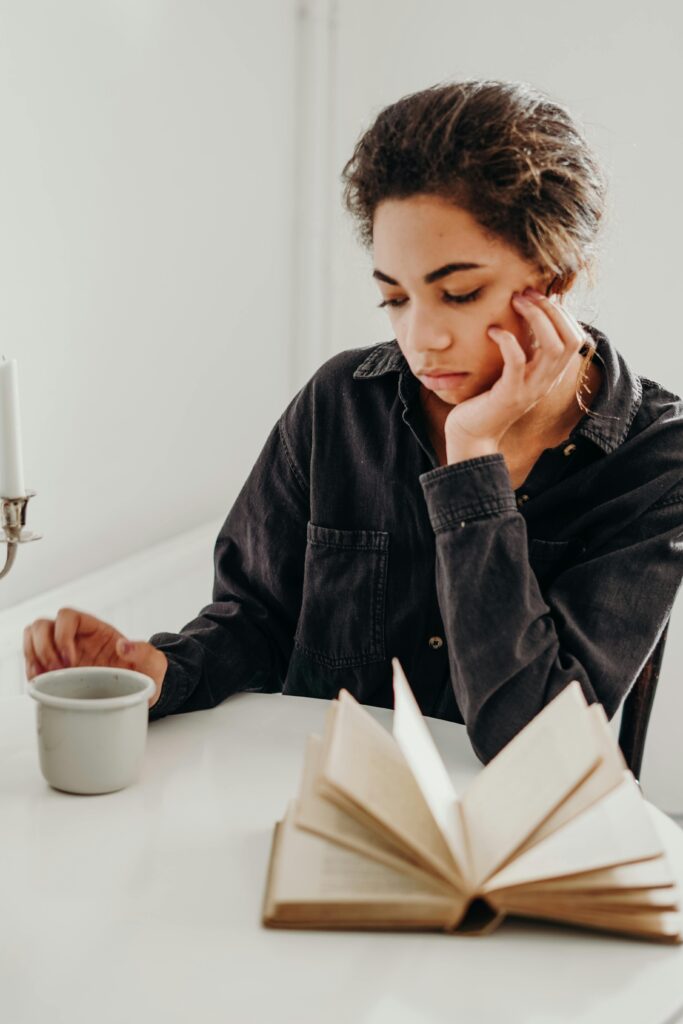 black woman pondering saying no while looking at her coffee cup